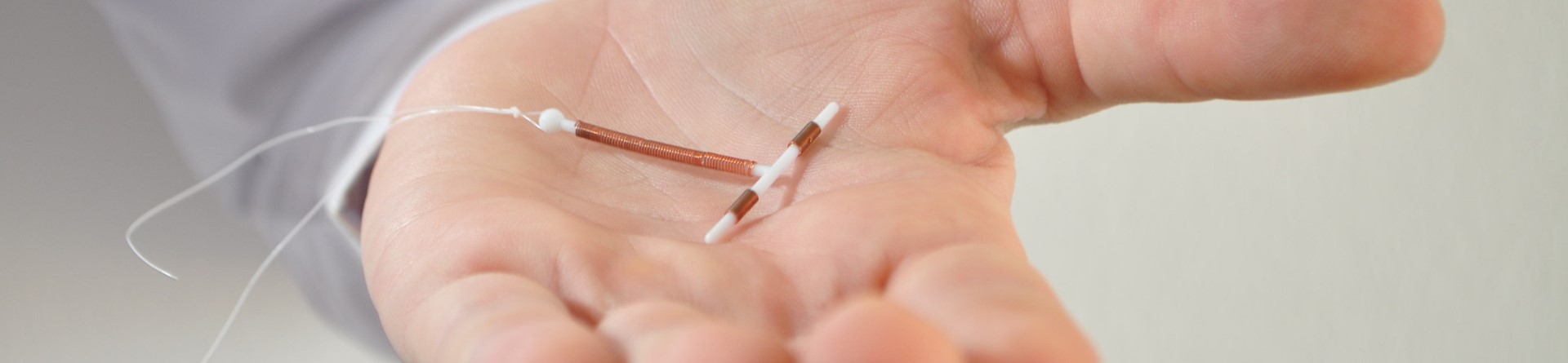 Photo of a hand holding a copper IUD