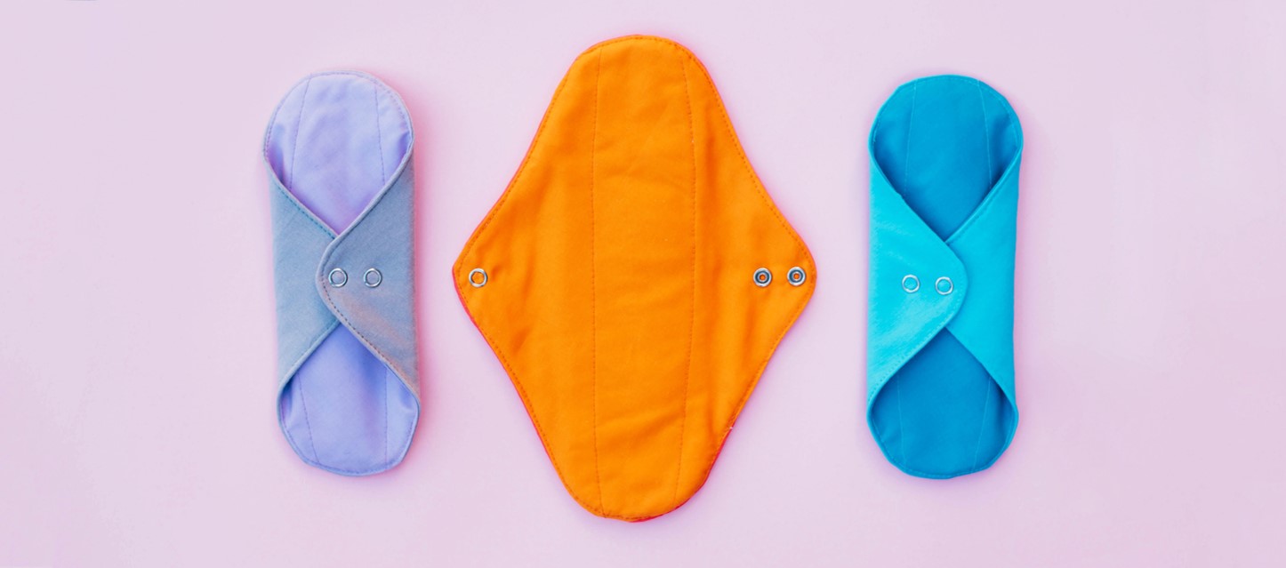 Photo of 3 cloth period pads on a purple background