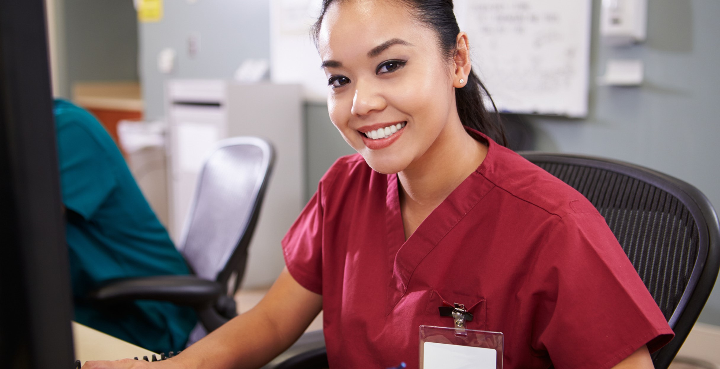 Photo of a nurse in red scrubs