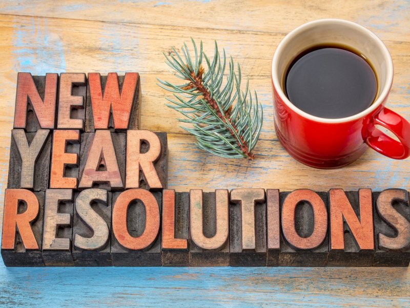photo of wooden blocks on table spelling "New Year Resolutions" next to a coffee mug