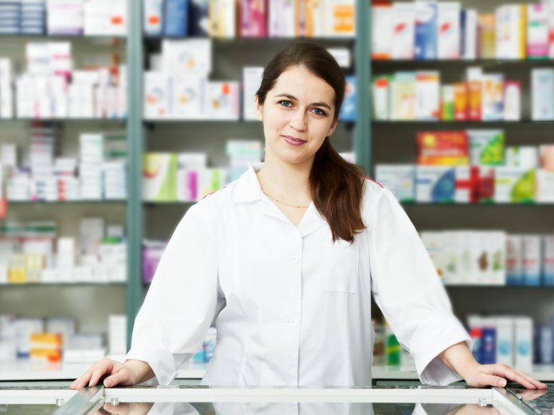 Photo of a pharmacist in front of shelves of medication