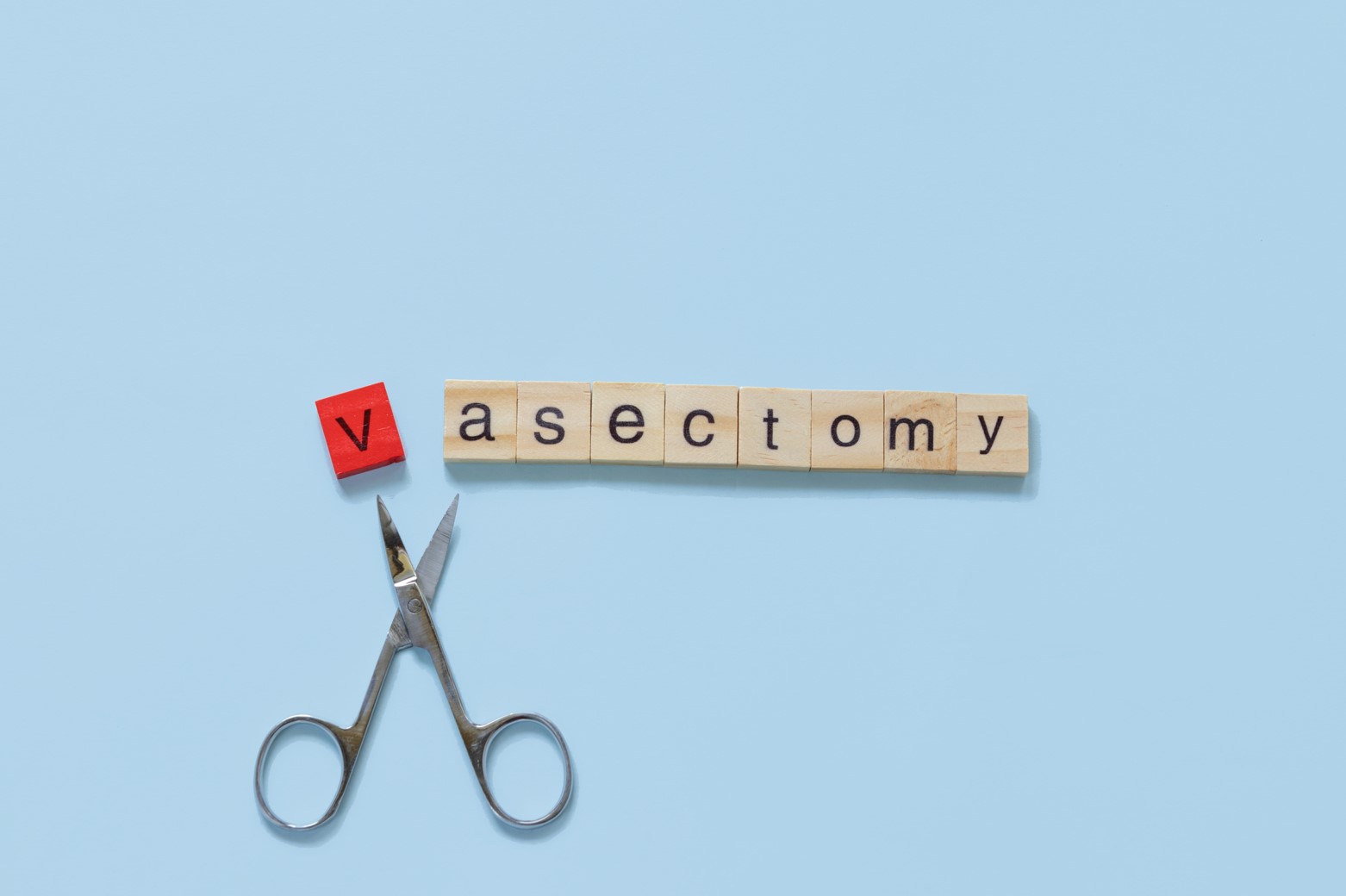 Photo of scrabble tiles spelling 'vasectomy' with a pair of scissors